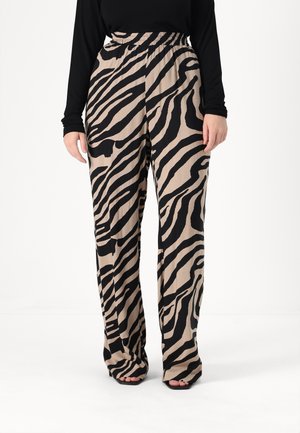 Løse, højhalsede bukser i et tan-stof med et iøjnefaldende sort zebra-print, der har en flad talje og brede ben.
