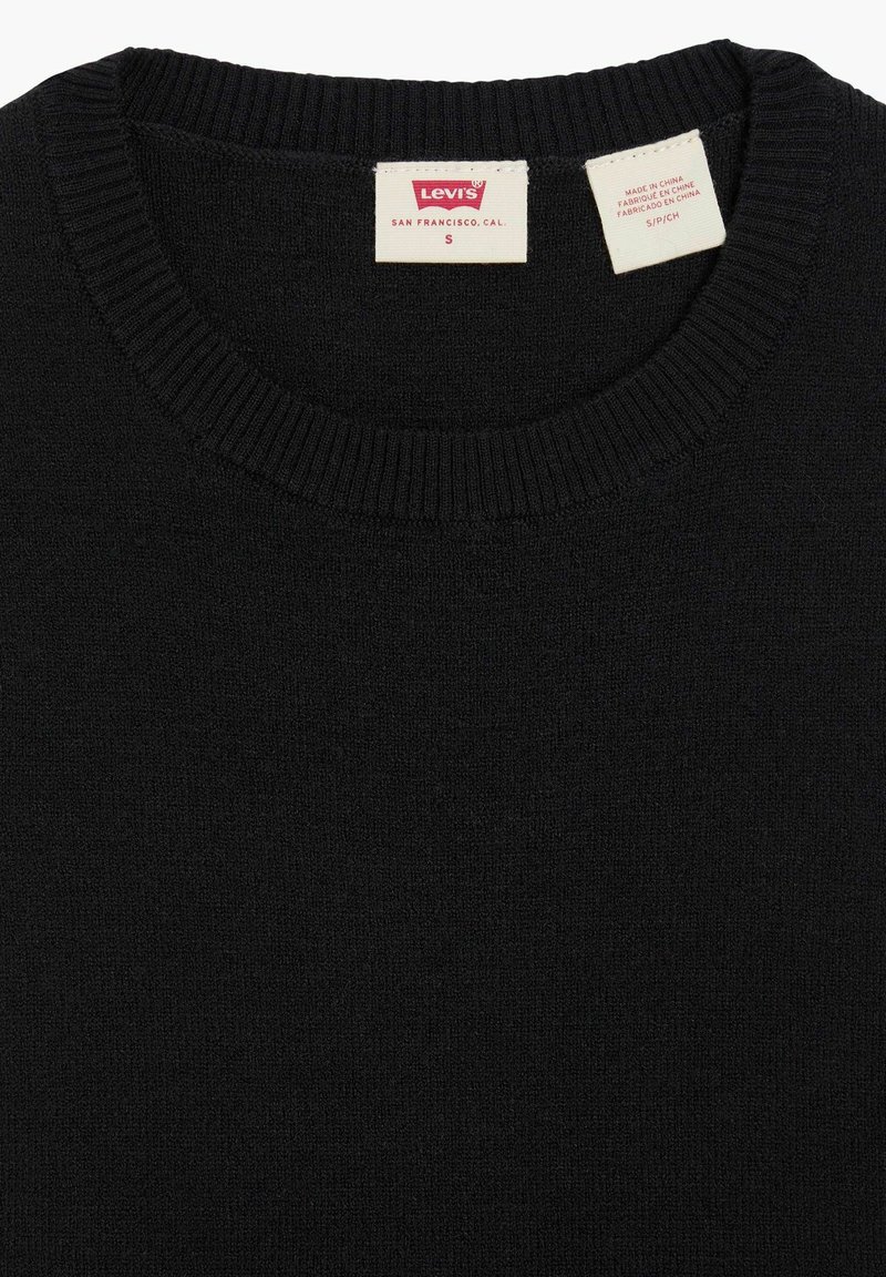 Suéter negro hecho de un material de punto fino. Tiene un cuello acanalado. Etiqueta de la marca visible en el interior con la talla 'S'.