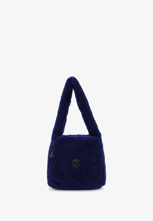 Navyblaue Plüsch-Schultertasche mit breitem Trageriemen, vorderer Reißverschluss-Tasche mit kleinem Anhänger und rundem Metall-Logo-Detail.
