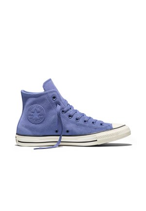 Paarse suède Converse sneaker met hoge schoenenzool, witte rubberen zool en neuskap, zichtbare veters en ronde logo patch op de enkel.
