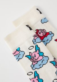 Cotton blend socks featuring cartoon pigs with wings on a cream background, accented with blue clouds and black outlines.