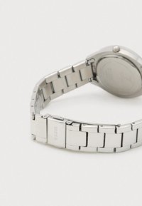 Sølvfarvet ur i rustfrit stål med ledarmbånd, rund urskive og poleret finish på rem og spænde.