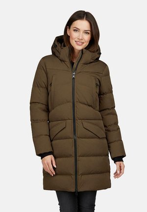 Vrouw draagt een lange olijfgroene gewatteerde winterjas met capuchon, ritssluiting aan de voorkant en klepzakken, staand en glimlachend tegen een witte achtergrond.
