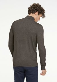 Mörkgrå tröja med krage, långa ärmar och ribbade muddar. Mjuk textur, figurnära design och medelhårdhet.