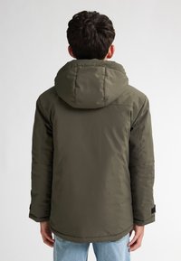 Jachetă puffer călduroasă de culoare khaki, cu o textură netedă și mansete elastice, având o glugă cu șnur și un croi lejer.