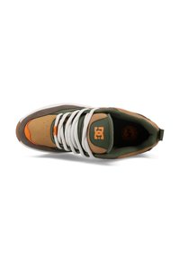 Sneaker featuring a combination of green, brown, and orange synthetic materials, with white laces and logo detail on the tongue.