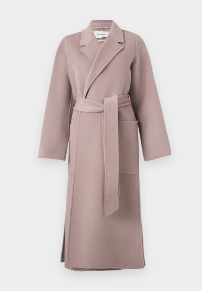 Μακρύ λιλά παλτό από μαλλί με φαρδιές πέτσες, δύο μπροστινές τσέπες, ζώνη δεμένη στη μέση και πλαϊνές σκισμένες, κρεμασμένο σε λευκό φόντο.