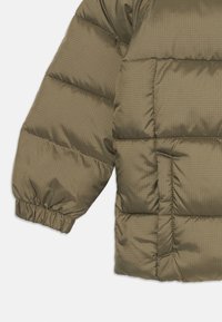 Olivenfarget puffjakke med langermet, quiltet design med horisontale seksjoner, elastiske mansjetter, subtil rutemønster og sydd detaljer.