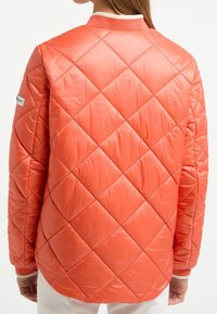 Quiltowany koralowy kurtka z diamentowym wzorem, elastycznymi mankietami i kontrastowym kołnierzem. Gładki, błyszczący materiał o luźnym kroju.