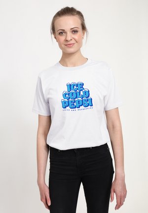 White cotton t-shirt featuring a blue graphic print that reads "ICE COLD PEPSI" with snow-like accents, paired with black jeans.