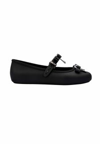 Zapato plano negro hecho de material suave, con un diseño flexible, con lazos decorativos y correas ajustables. Silueta de bajo perfil.