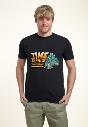 Schwarzes Baumwoll-T-Shirt mit einem grafischen Druck eines Dinosauriers mit blauen Stacheln und dem Text "ZEITREISENDER AUS EINER ANDEREN WELT JURASSIC PORTAL."