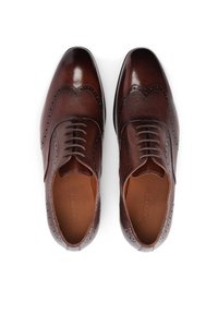 Bruine leren dresschoenen met brogue-details, voorzien van een gladde neuskap en textuur op de zijkanten, veters, en een contrasterende zool.