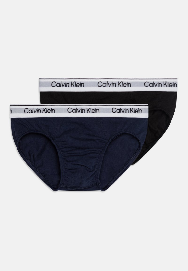 Dve páry spodnej bielizne: jedna tmavomodrá a jedna čierna. Obe majú biely elastický pás s logom "Calvin Klein". Mäkká tkanina, strih slipov.