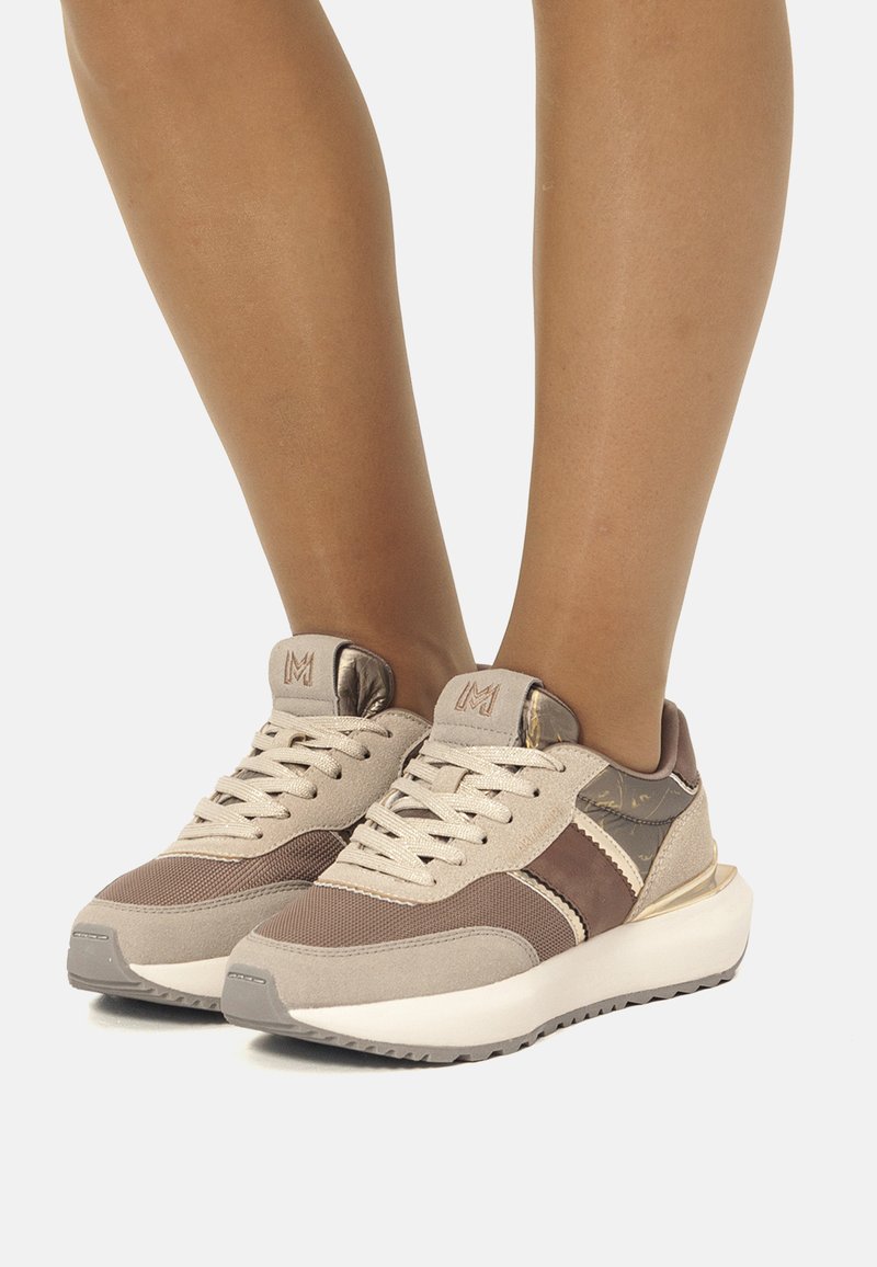Sneaker beige e marroni in materiali mesh e suede, design con lacci, dettagli metallici e suole in gomma bianca spessa.