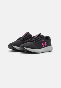 Scarpe da ginnastica nere con una texture liscia, dettagli rosa e logo. Dispongono di una suola ammortizzata e un design elegante e aerodinamico per le performance.