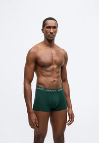 Sötétzöld boxeralsó a GANT logóval díszített derékrésszel, puha anyagból készült, testhezálló fazonú és sima tapintású.