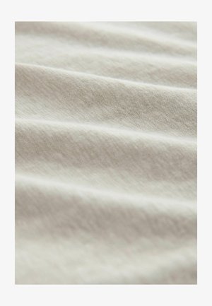 Heledast beež kangas, millel on sile ja tekstuurse pinnaga, näidates õrnu värvuse ja mustri variatsioone õrnalt volditud kihtidel.