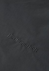 Black textured fabric with "H2OFagerholt" logo embroidered in a subtle font. Soft, lightweight material suitable for casual wear.