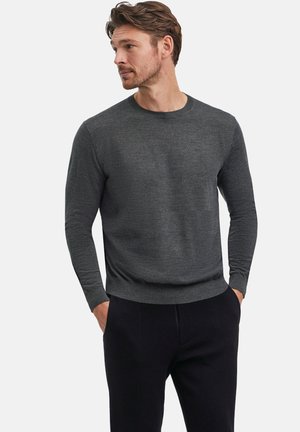 Dark gray knitted sweater with a crew neckline and long sleeves, featuring a smooth texture and a fitted hem, paired with black pants.
