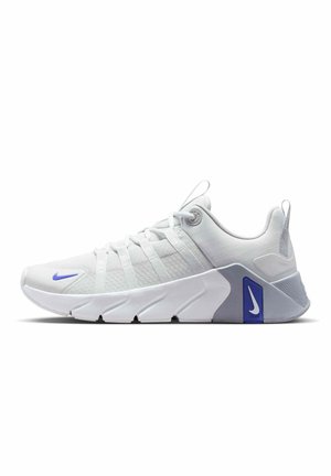 Baskets de sport blanches avec dessus en mesh, semelle blanche inclinée distinctive, logo Nike bleu près des orteils et du talon, et languettes de traction sur la languette et le talon.