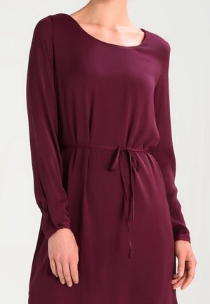Robe longue bordeaux à manches longues avec un col arrondi, coupe cintrée et lien ajustable à la taille ; dotée de poignets boutonnés et d'une texture de tissu lisse.