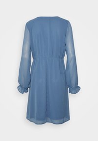 Vestido azul de manga larga en tejido ligero, con cintura fruncida y puños elásticos, de textura suave y diseño sencillo.