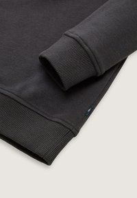 Donkergrijze sweatshirt met geribde manchetten en onderrand, een zachte textuur en een klein logo-label aan de zijkant.