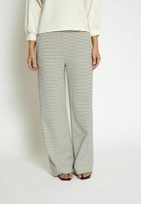 Black and white patterned wide-leg pants with a textured fabric, featuring a grid-like design and a high waist.