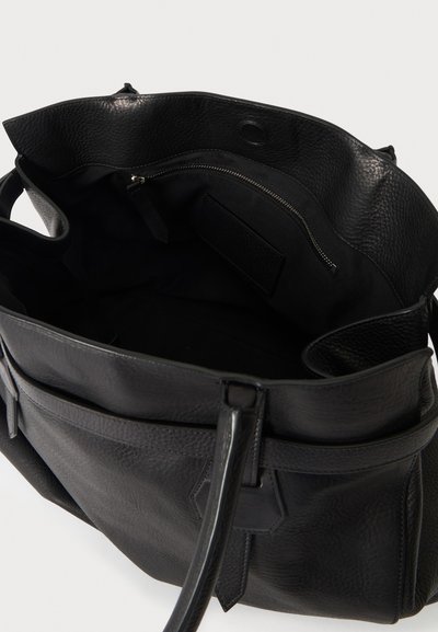 Sac à main en cuir noir avec ouverture supérieure, doté d'une poche intérieure zippée et de doubles poignées.