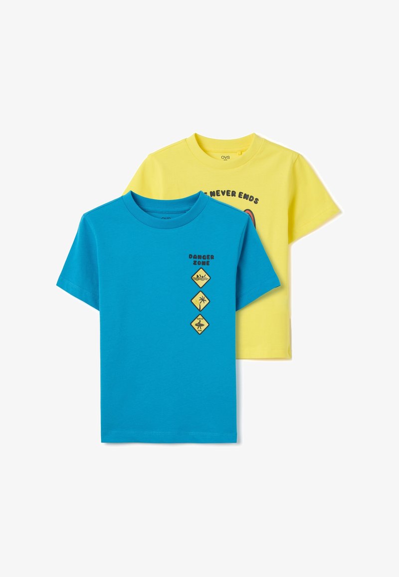 Dos camisetas de algodón: una turquesa con "ZONA PELIGROSA" y símbolos gráficos, la otra amarilla con un diseño circular y texto. Manga corta.