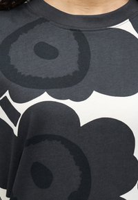 Γκρι φούτερ με μεγάλο σκούρο λουλουδάτο σχέδιο σε μαύρο και κρεμ, με στρογγυλή λαιμόκοψη και μαλακό, υφασμάτινο υλικό.