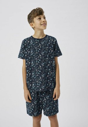 Ensemble de pyjama à manches courtes de couleur bleu marine avec un imprimé sur le thème de l'espace. Tissu doux, présentant des planètes et des fusées, avec un short assorti.