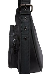 Svart nylon skulderveske med en glidelåslomme, bred stropp med metallspenne, og grommetdetaljer. Glatt tekstur med matt finish.