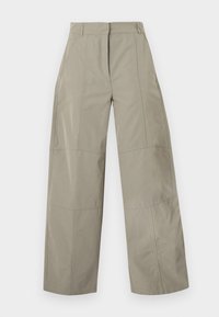 Παντελόνια σε μπεζ ανοιχτή γραμμή με τσέπες μπροστά, θηλιές για ζώνη και εμφανείς ραφές σε απλό φόντο.