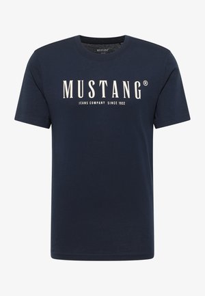 Tumši zila kokvilnas T-krekls ar īsām piedurknēm, uz priekšpuses baltā krāsā izdrukāts logo "MUSTANG JEANS COMPANY SINCE 1932".