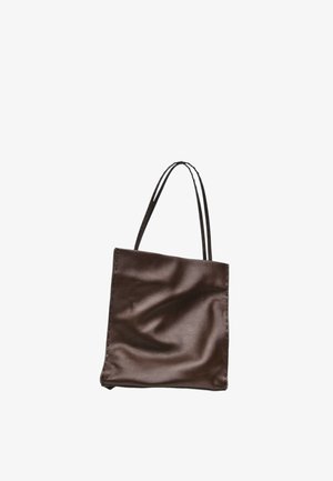 Sac cabas en cuir marron avec deux fines anses d'épaule et une texture légèrement froissée sur fond blanc.