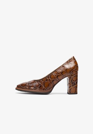 Pompe en cuir marron avec un motif rond texturé. Présente un bout pointu et un talon bloc robuste, mettant en valeur une finition brillante.