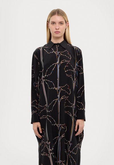 Čierne šaty s dlhým rukávom a golierom, ktoré majú multikolórové abstraktné vzory listov a gombíkový zapínací systém na prednej strane.