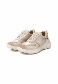 Zapatillas deportivas beige con un upper sintético liso, acentos texturizados, cordones elásticos y una suela acolchada. Diseño ligero.