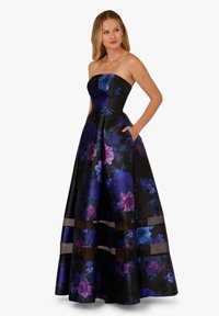 Czarna sukienka kwiatowa o straplessowym kroju, z purpurowymi i niebieskimi kwiatami, pełną spódnicą i kieszeniami. Akcenty w postaci overlayu w pobliżu dolnej krawędzi.