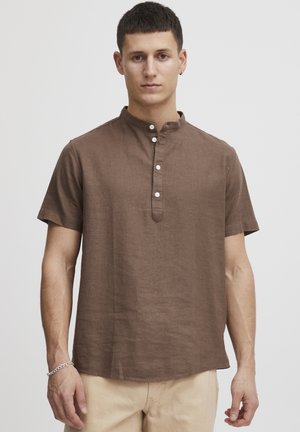 Short-sleeve brown linen shirt with a mandarin collar, featuring six white buttons along the front. Smooth texture and relaxed fit.