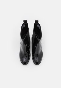 Black patent leather ankle boots with smooth texture, rounded toe, elastic side panels, and pull tabs for easy wear.