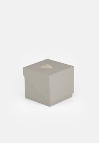 Cutie de cadou pătrată din material gri deschis texturat, cu un logo triunghiular aurit pe capac și un design cu capac pliabil.