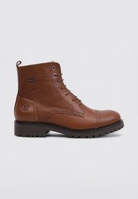 Botas de tobillo de cuero marrón con punta redonda, parte delantera con cordones, ojales de metal y suela texturizada. Presentan un detalle de costura y un acento de logo.