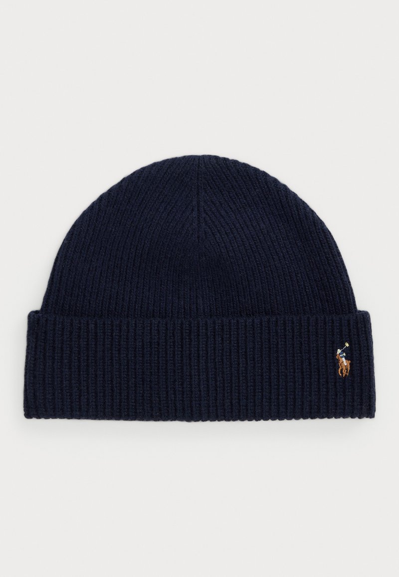 Căciulă tricotată rib și bleumarin cu un mic logo de jucător de polo brodat pe manșeta pliată, pe fundal alb.