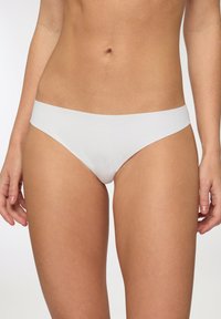 Slip bikini bianco realizzato in tessuto morbido con design senza cuciture e vita media. Presenta un taglio minimalista e nessun hardware visibile.