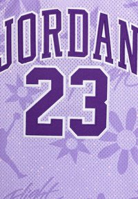 Canotta da basket viola in rete con la scritta "JORDAN" e il numero "23" in grassetto con bordo bianco. Lo sfondo presenta motivi floreali in una tonalità di viola più chiara.