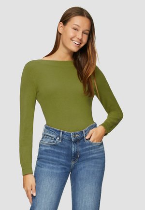 Pull vert olive à manches longues avec un décolleté large, associé à un jean en denim bleu avec un design classique à cinq poches.