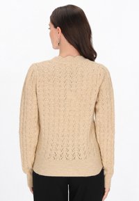 Maglione lavorato a maglia in beige chiaro con motivo a diamante testurizzato, polsini a coste e scollo rotondo, caratterizzato da una vestibilità rilassata e maniche lunghe.